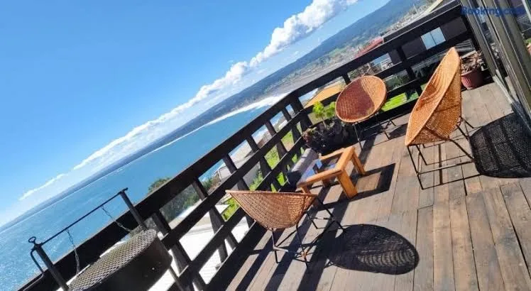 Terraza techada del hotel con sillones y vista hacia el jardín