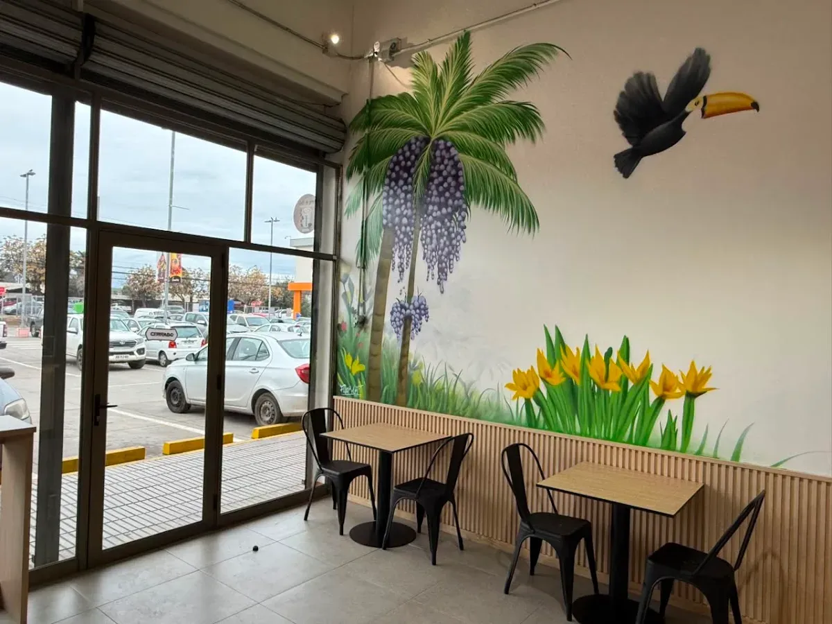 Mesas junto al mural de palma de açaí y el ventanal a Lircay
