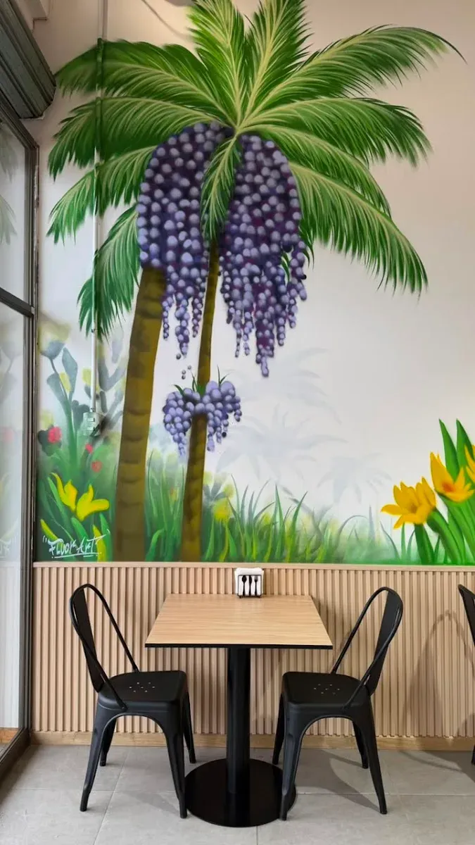 Mural de racimos de açaí y tucán pintado en el local