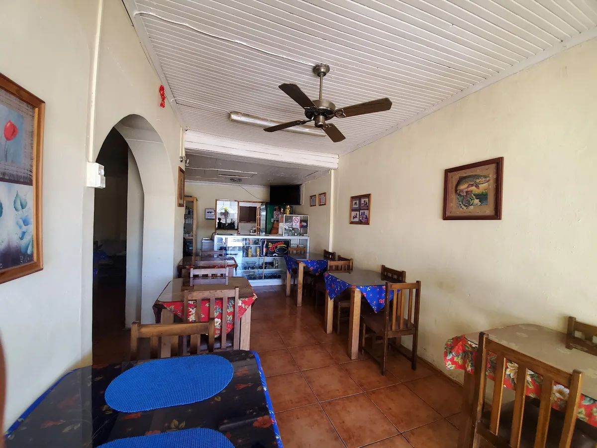 Interior del hostal Aleros de Molina: comedor con mesas y ventiladores