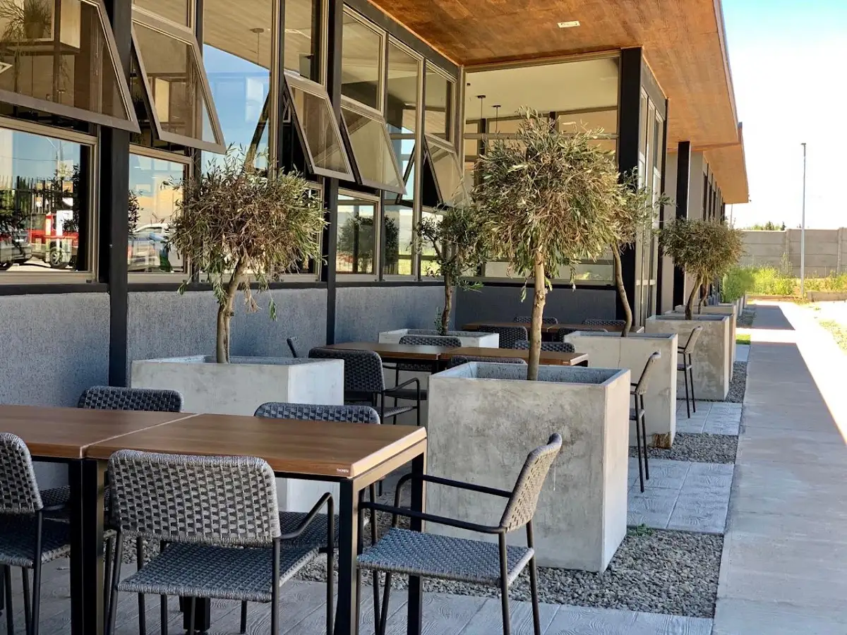 Terraza de Alma restaurant con mesas y jardineras