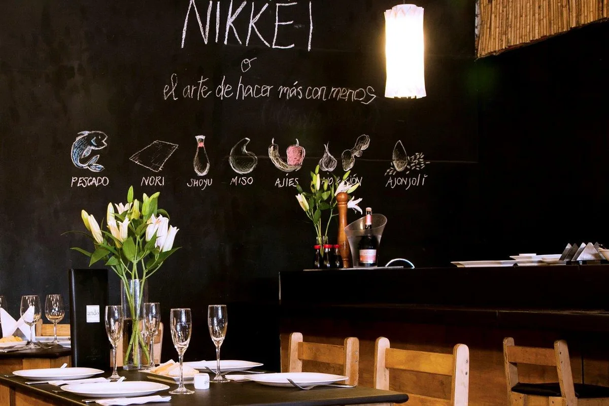 Salón de Andö en Curicó: mesas de madera y la pizarra mural «nikkei, o el arte de hacer más con menos»