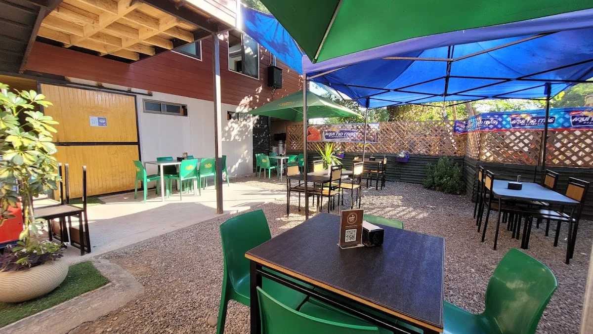 Terraza del restorán con sombrillas y sillas verdes