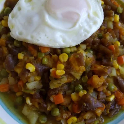 Charquicán con verduras y un huevo frito encima