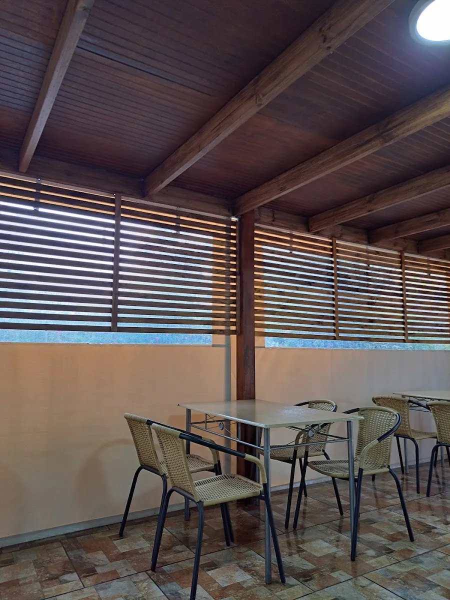 Terraza techada de madera con mesas y sillas del restaurante