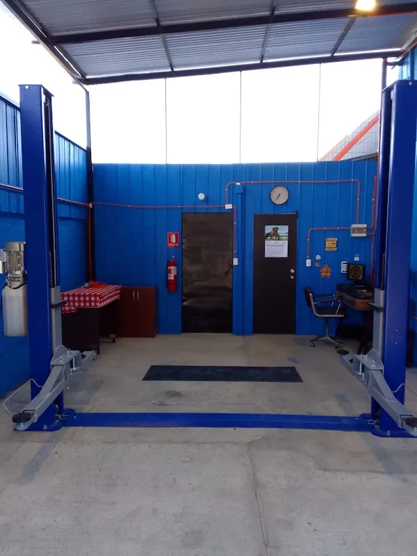 Interior del box del taller Mario Salinas con sus muros azules y herramientas