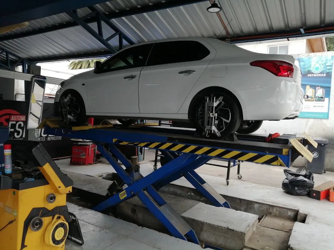 Auto levantado en el elevador hidráulico del taller Mario Salinas, Talca
