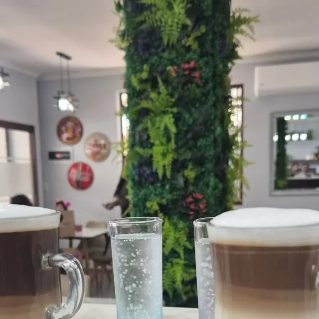 Cafés de Café Baires servidos en mesa de mármol frente a la columna verde