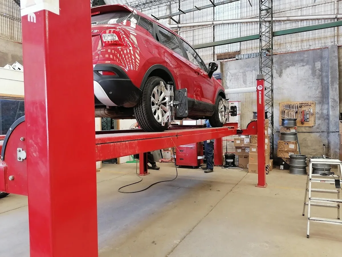 Auto rojo en la alineadora de Bodega Liquidadora de Neumáticos