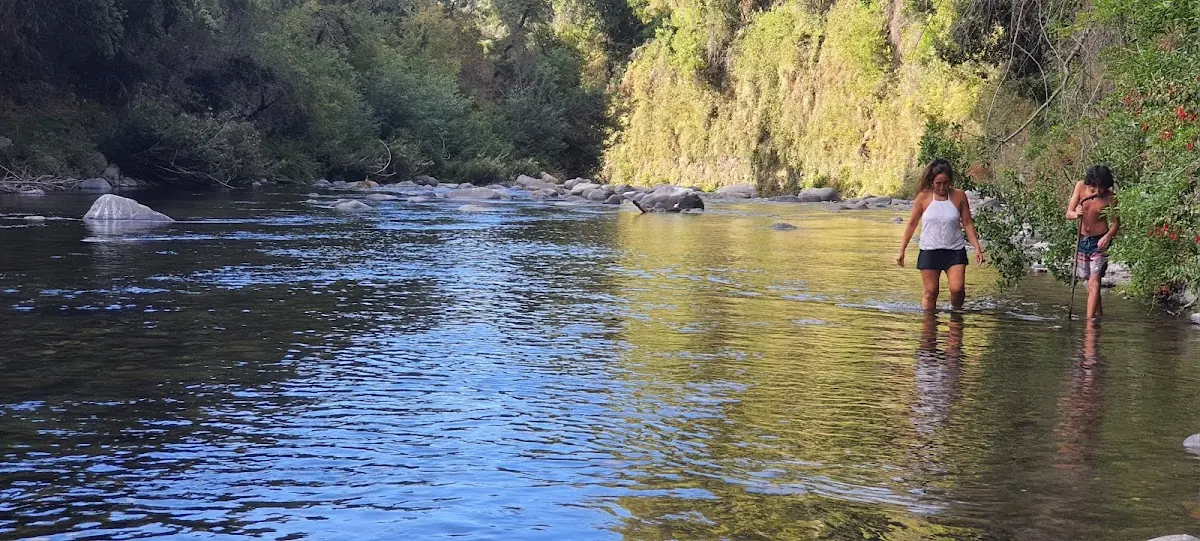 Visitas bañándose en el río Claro junto a las rocas