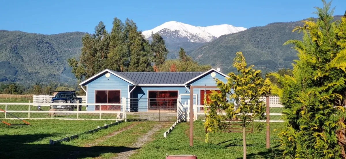 Cabaña de madera con la cordillera nevada de fondo en Cabañas Las Lomas, San Clemente