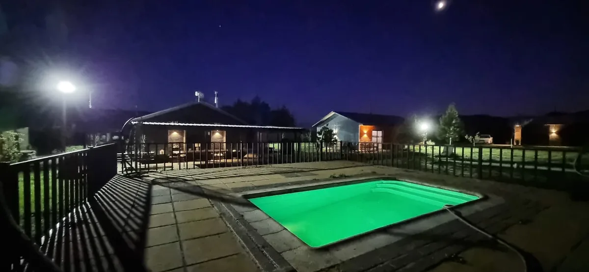 Piscina de Cabañas Las Lomas iluminada de noche
