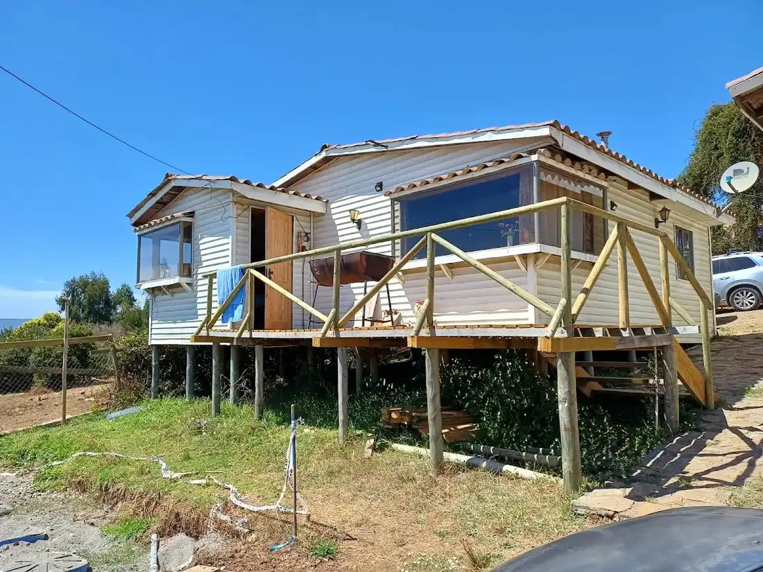 Dormitorio de la cabaña con cama y revestimiento de madera