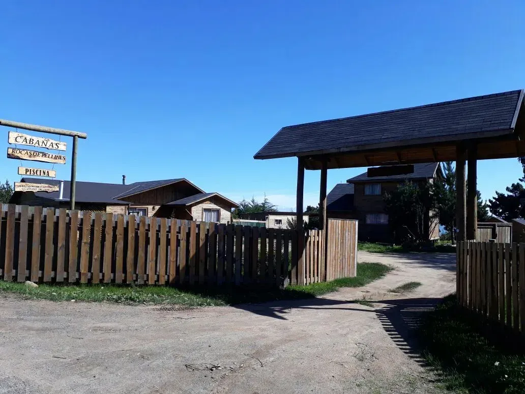 Piscina del complejo con juegos infantiles y cerros verdes al fondo