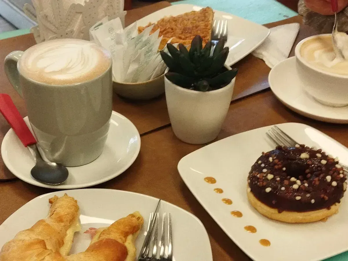 Mesa de Cactú con cafés, donut de chocolate, croissant y suculenta de centro