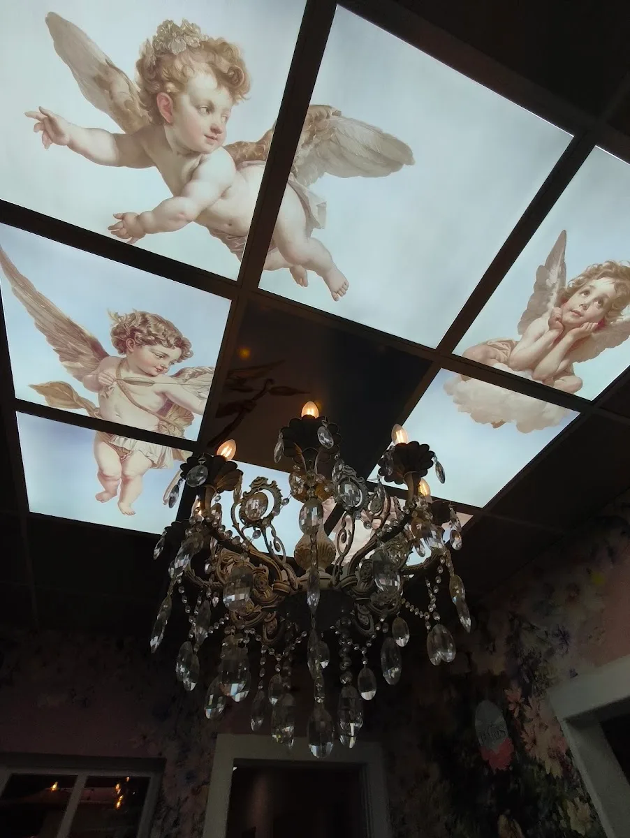 Techo pintado con querubines y candelabro en Café París