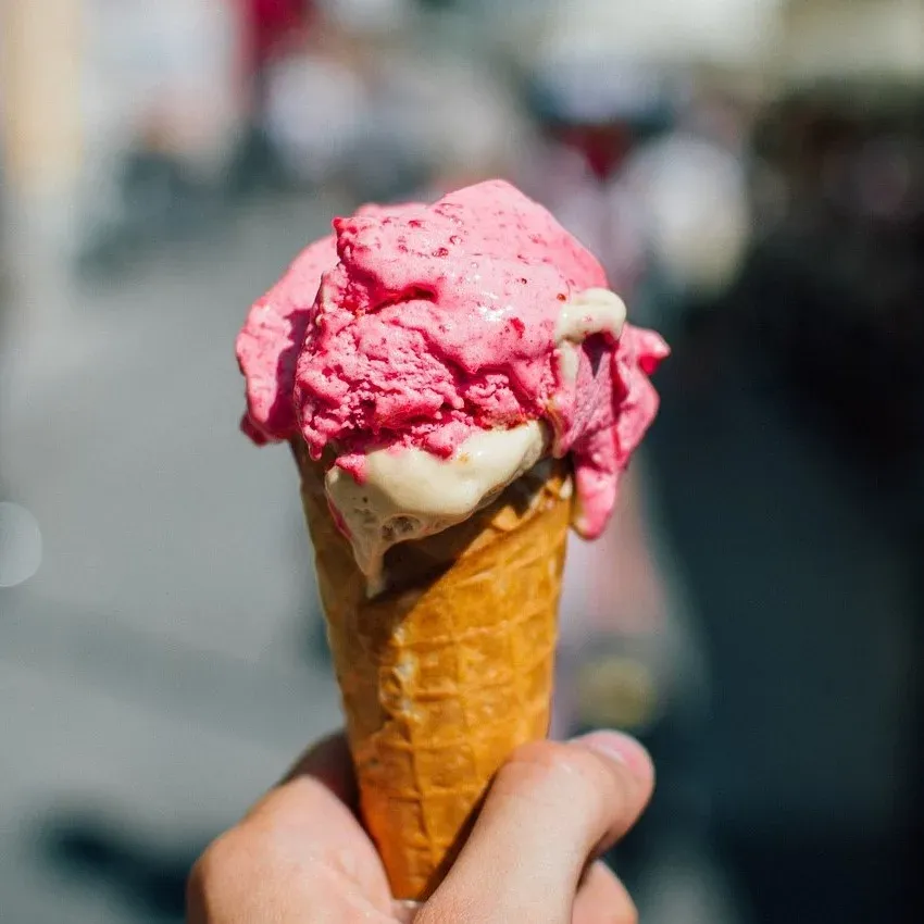 Cono de helado rosado en la mano, heladería Los Nogales