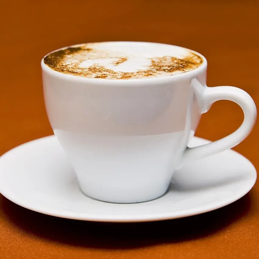 Taza de espresso sobre fondo naranjo, Cafetería Los Nogales