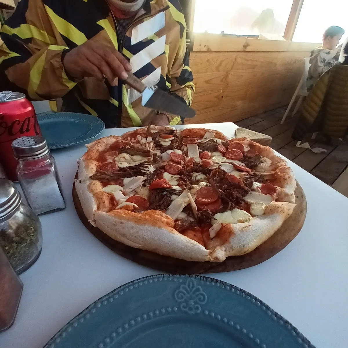 Pizza recién salida sirviéndose en la terraza de Calypso