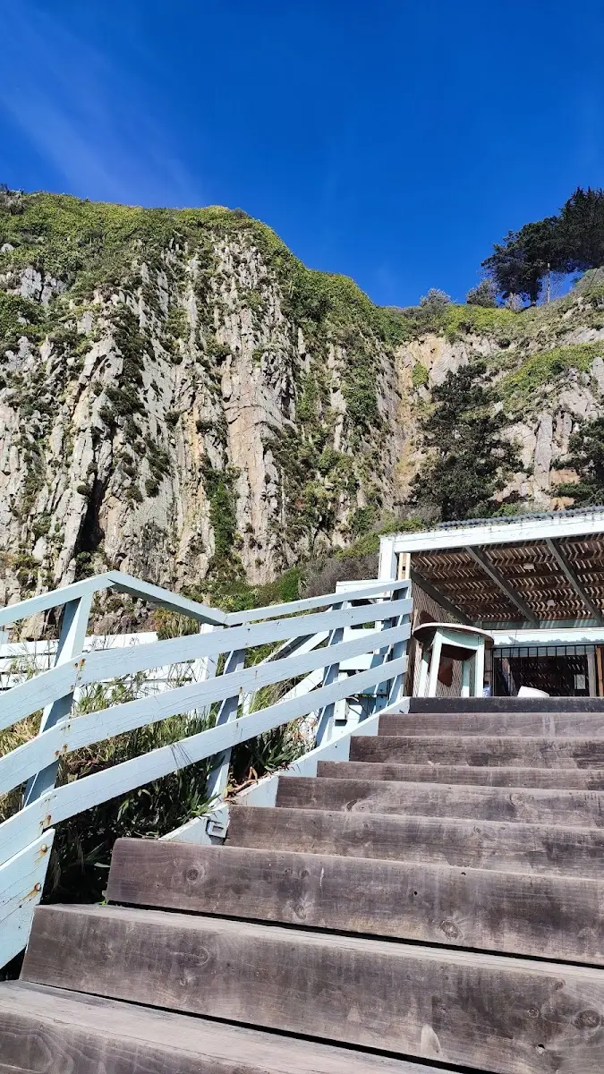 Escalera blanca que baja desde Calypso hacia la playa en Constitución