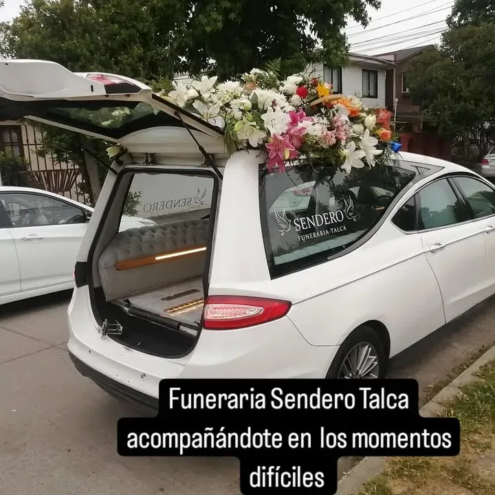 Carroza fúnebre blanca coronada de flores