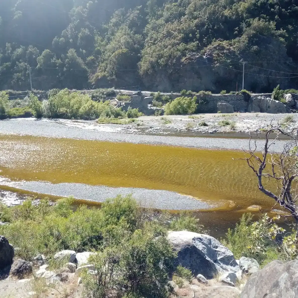 El río Maule pasando entre rocas y vegetación junto al camping