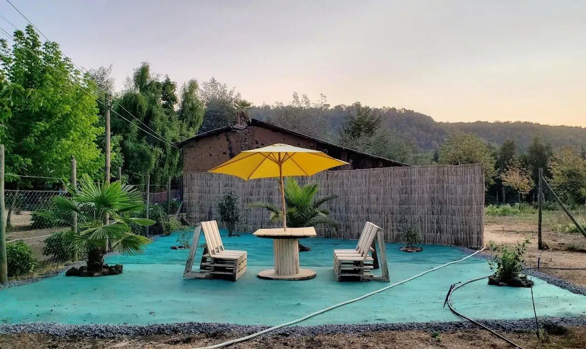 Quincho y piscina del Camping Los Castaños al atardecer