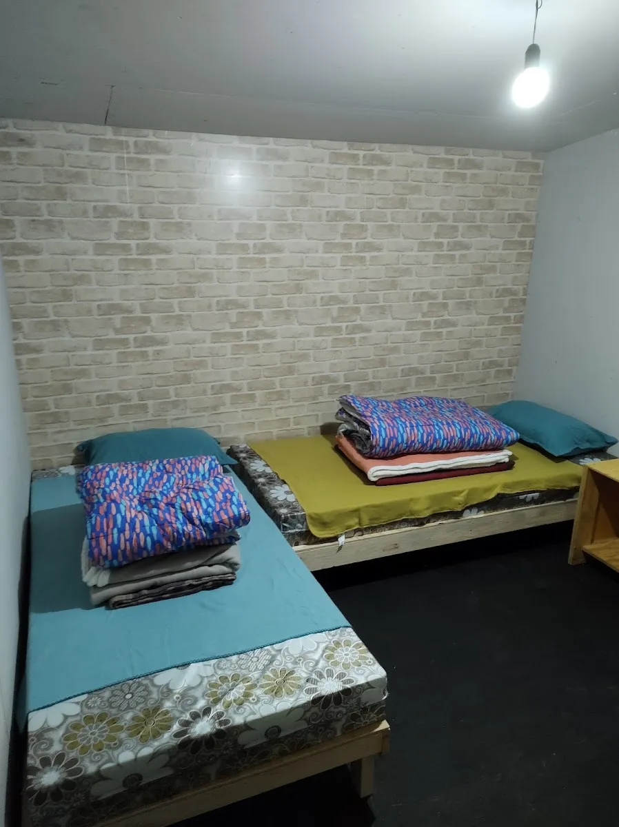 Interior de cabaña con camas blancas y muebles de madera