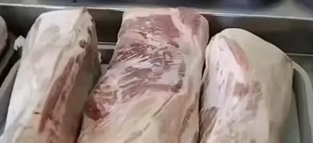 Cortes de vacuno y longaniza en bandejas dentro de la vitrina de la carnicería
