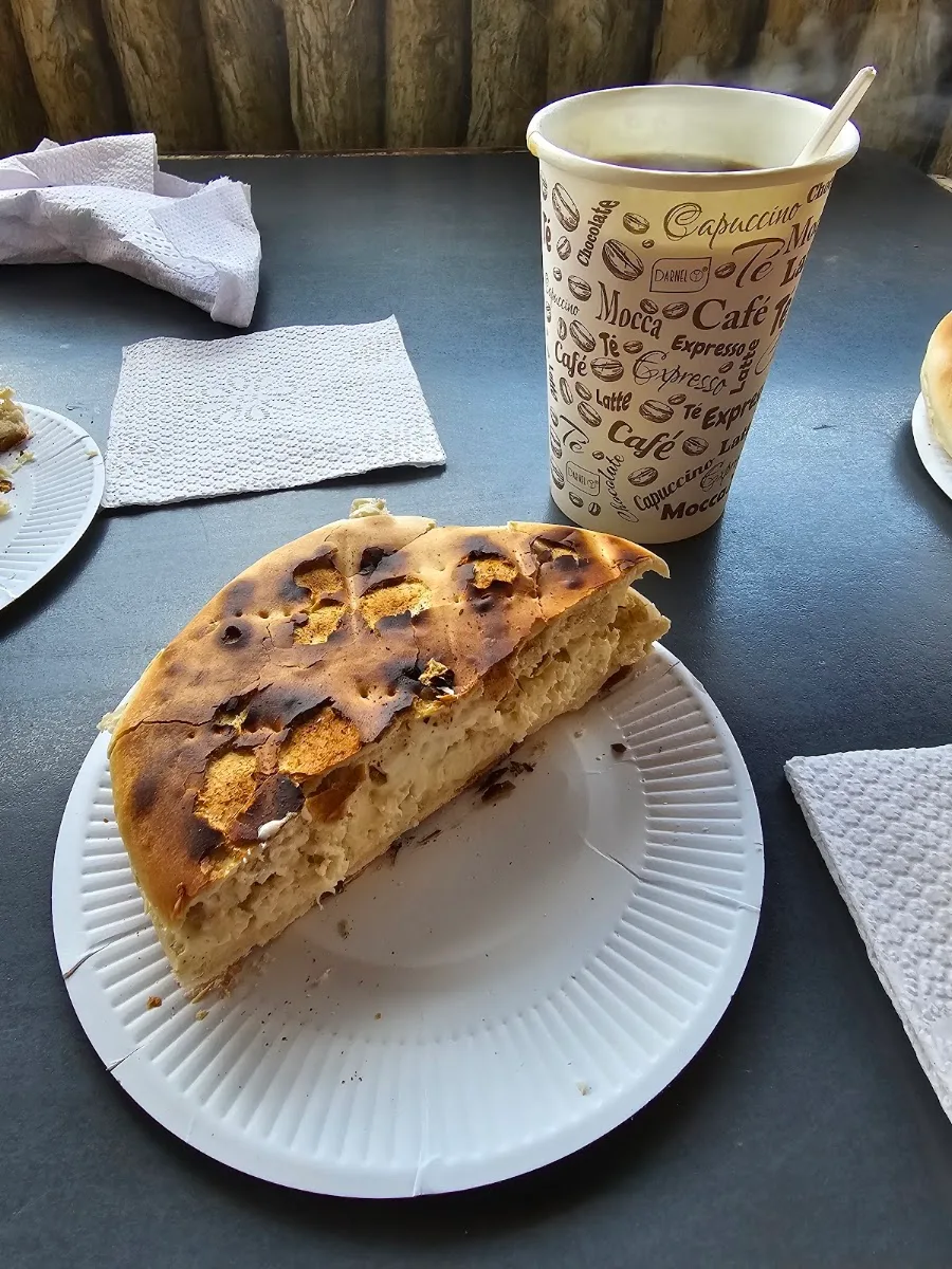 Sandwich en pan amasado con taza de café sobre la mesa del carro
