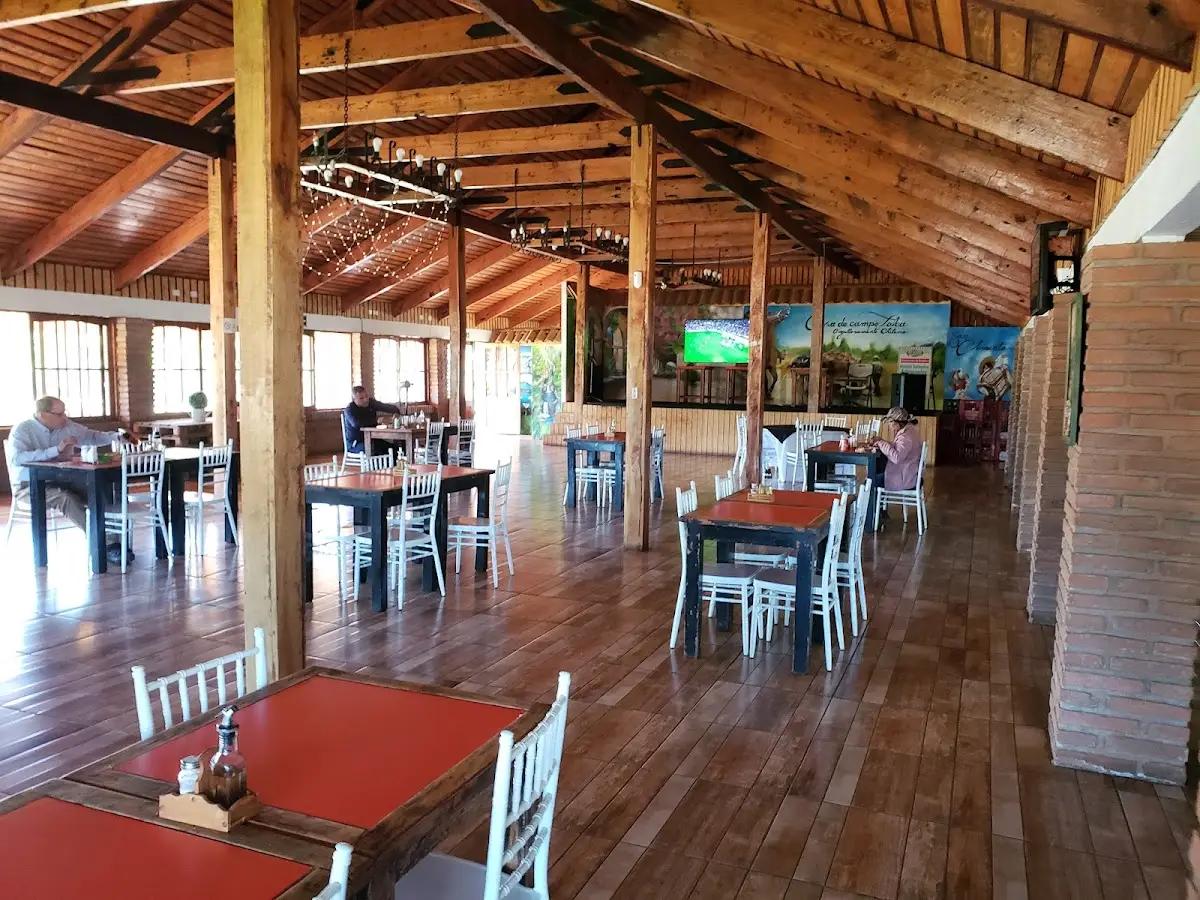 Salón comedor de Casa de Campo: techo de madera y mesas con mantel rojo