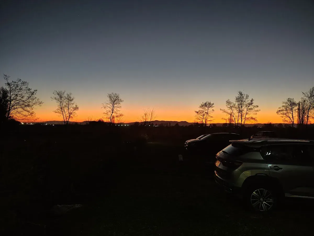 La Casa del Toto al atardecer sobre Av. Quilvo en Romeral, con el cielo dorado detrás del portón