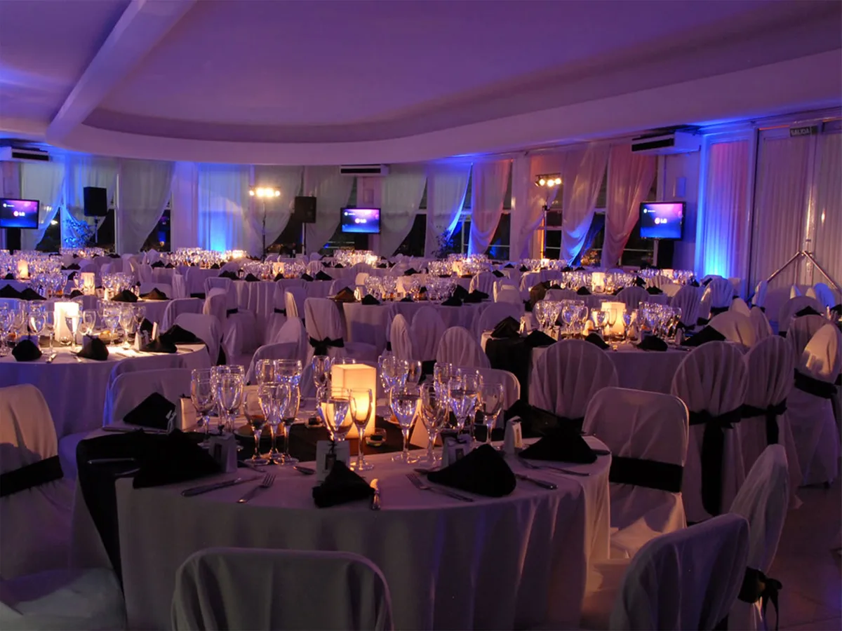 Salón principal de Casona Las Camelias con mesas montadas e iluminación