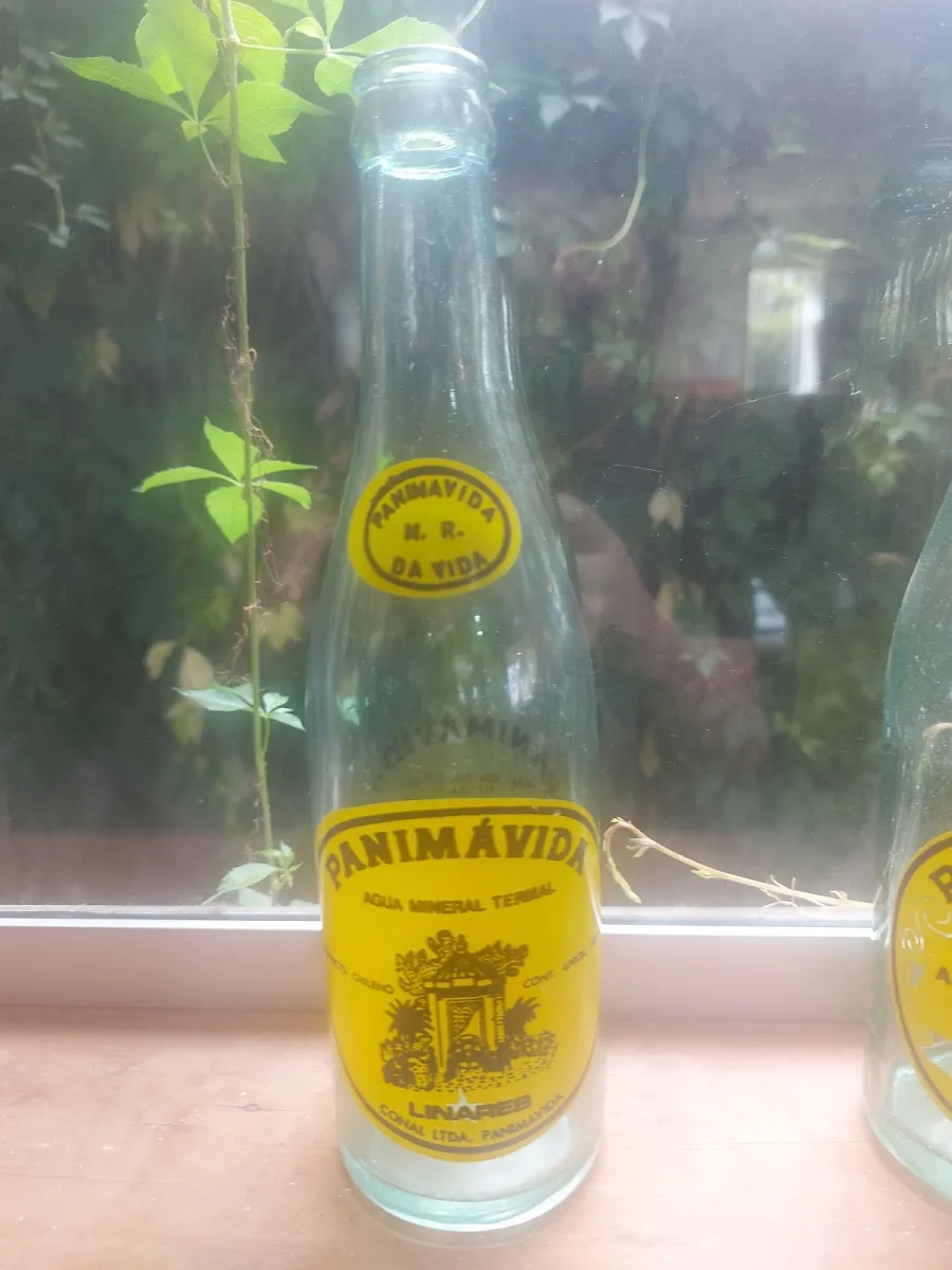 Botella de vidrio de agua mineral Panimávida con etiqueta amarilla