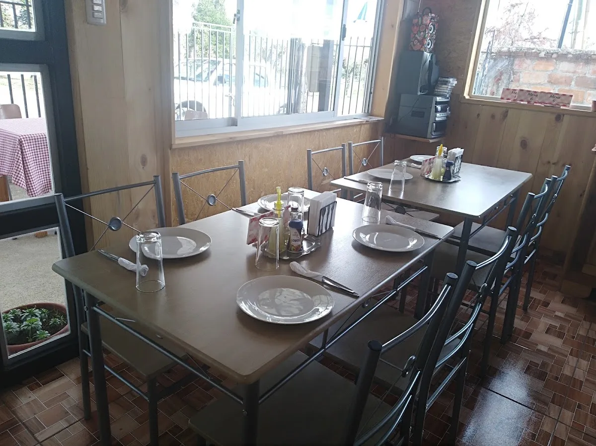 Comedor interior del restaurante con mesas servidas junto a las ventanas