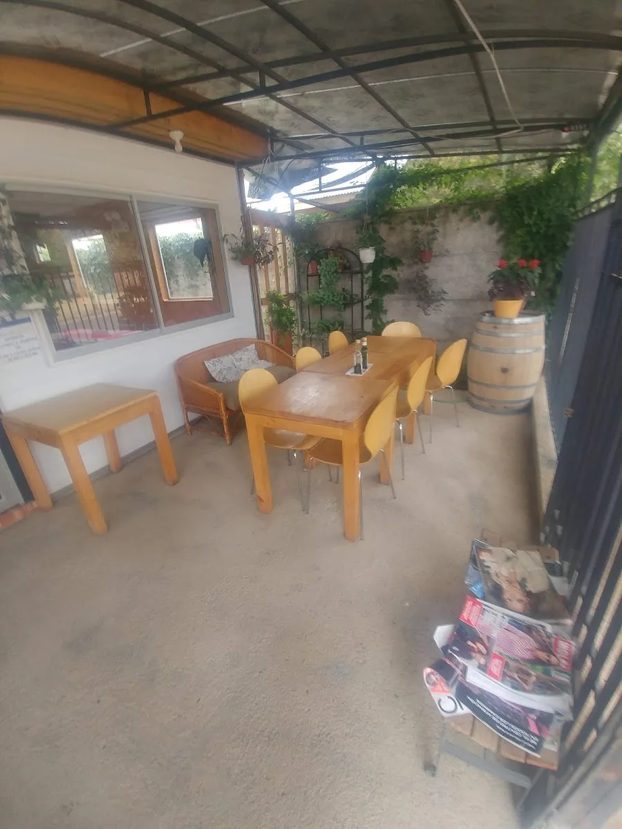 Quincho interior con barrica, sillas amarillas y plantas colgantes
