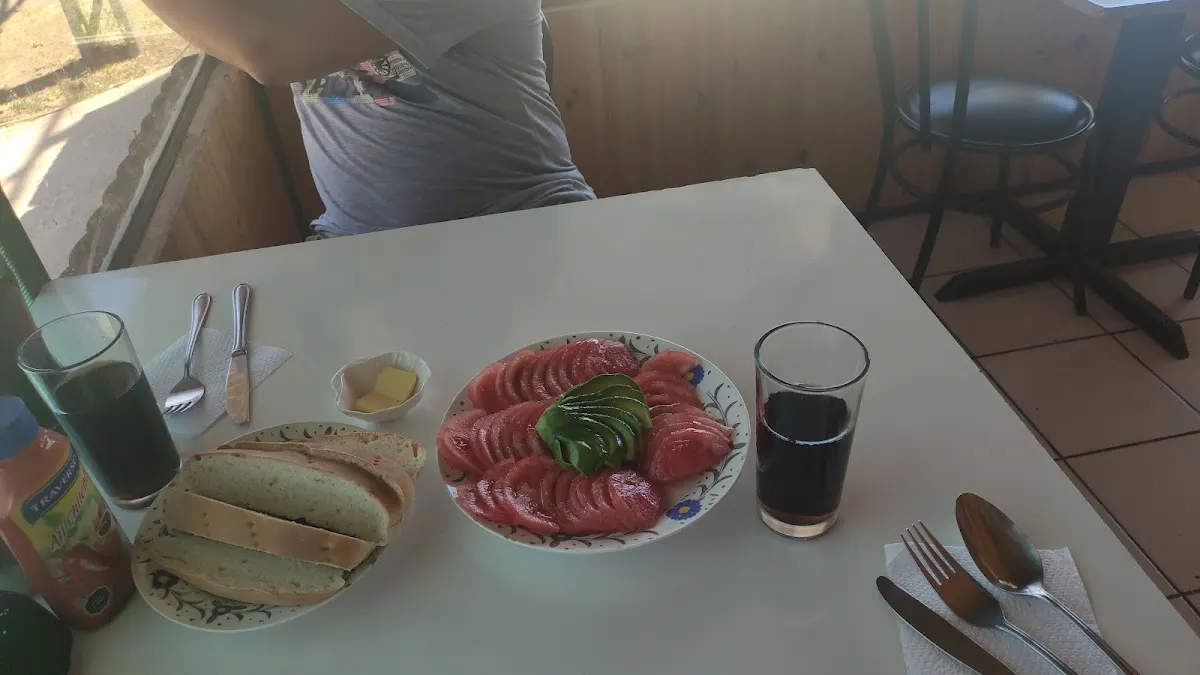 Sándwich casero con carne y palta al medio de la mesa