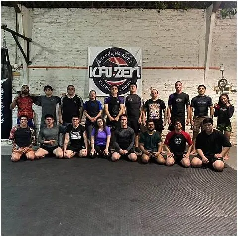 Grupo de grappling no-gi de Kaizen frente al logo del dojo