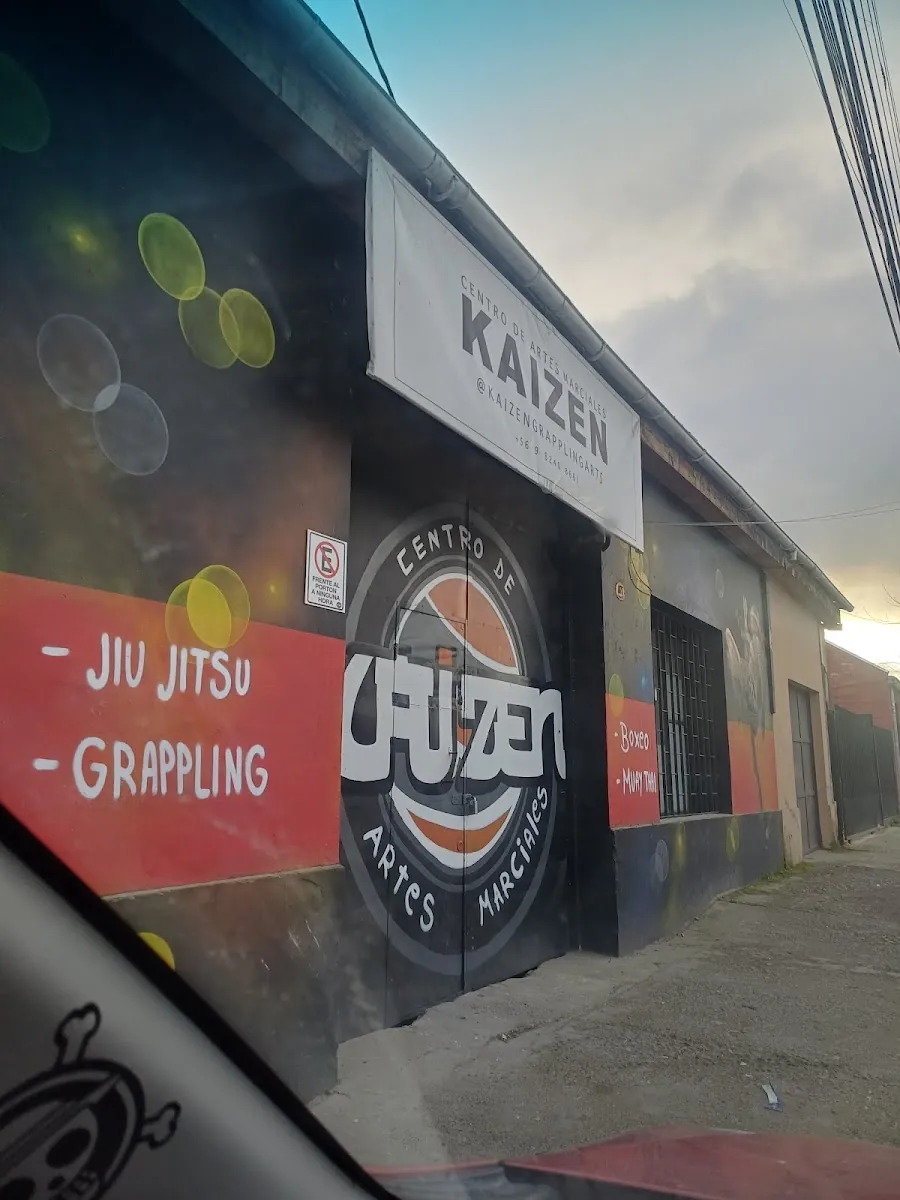Fachada del Centro de Artes Marciales Kaizen con el mural que lista jiu jitsu, grappling, boxeo y muay thai
