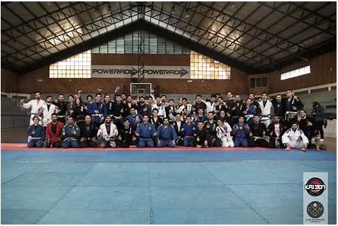 Foto grupal de Kaizen tras un torneo de jiu jitsu en gimnasio con tatami azul