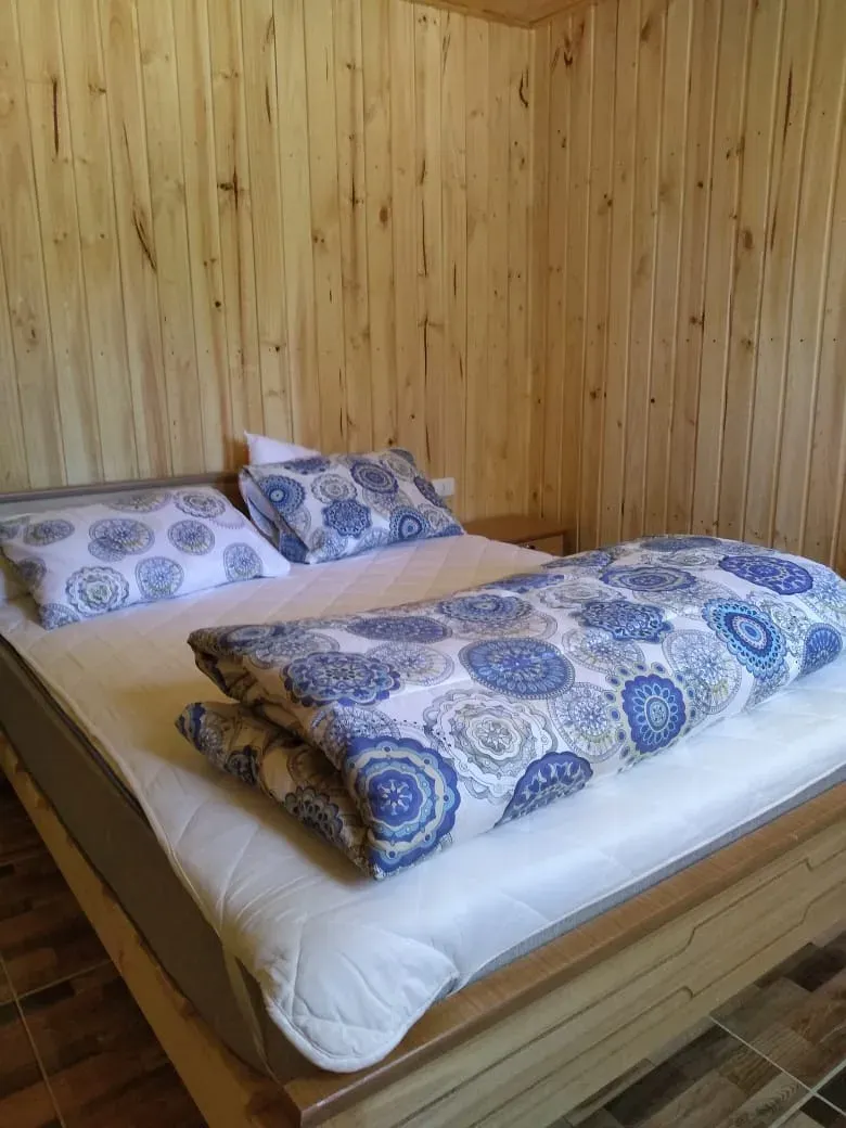 Dormitorio de cabaña con cama de madera y ropa de cama