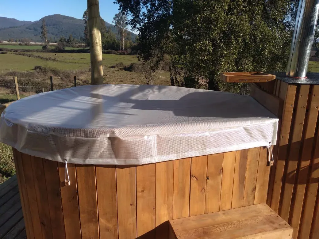 Tinajas de madera bajo una pérgola en el Centro Turístico Rayen