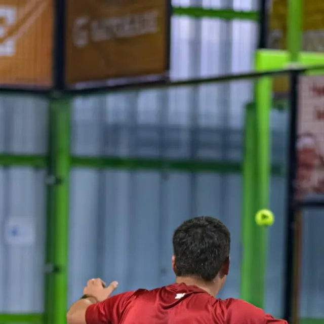 Jugador de rojo sacando bajo el banner Gatorade de la pista