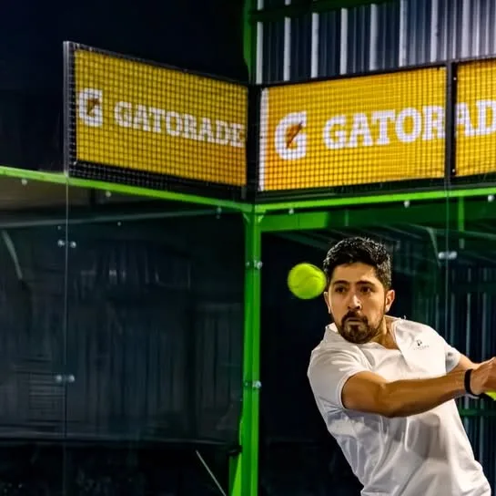 Jugador ejecutando un drive de derecha frente al muro de vidrio