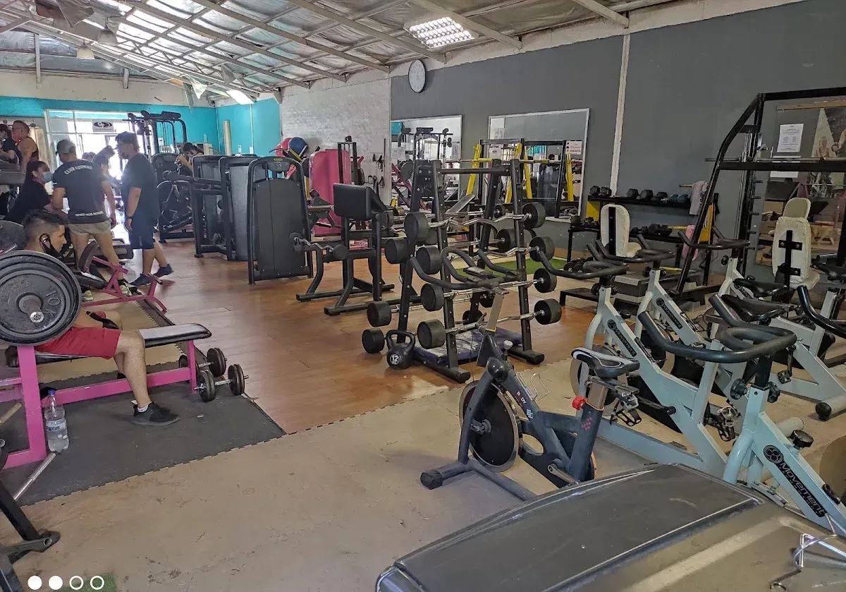 Sala de máquinas de Club Formas en Molina: bicicletas, racks y zona de peso libre con socios entrenando