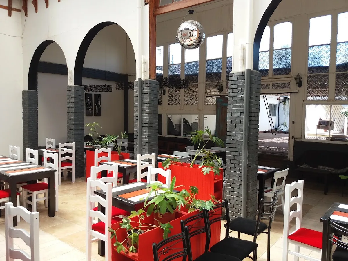 Salón del club con paredes rojas, lámparas y cuadros