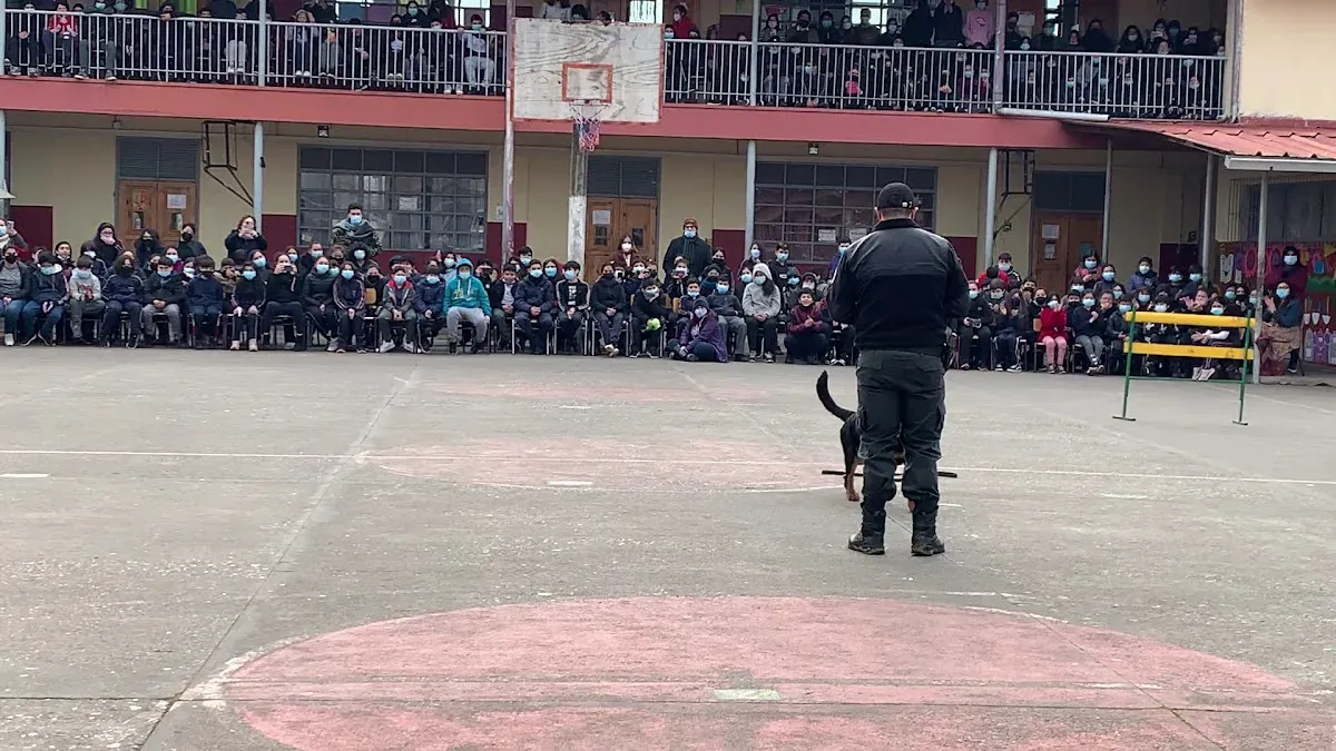 Comunidad escolar reunida en el patio techado durante una actividad