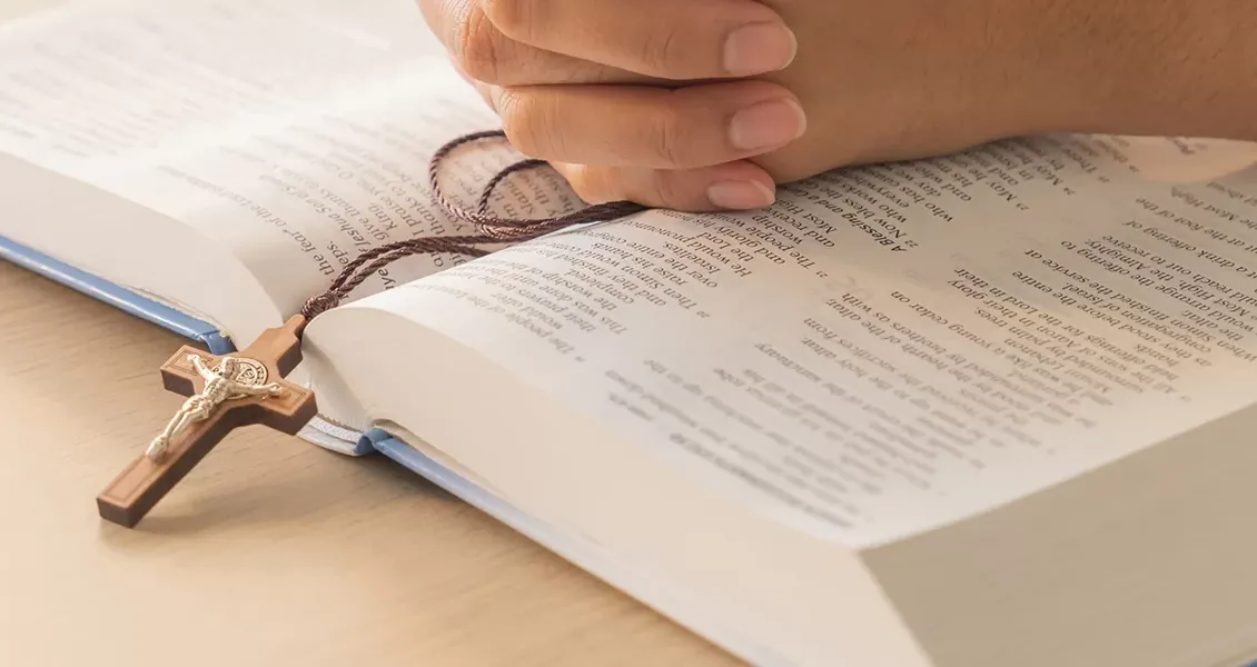 Biblia abierta con cruz de madera, símbolo de la formación del colegio