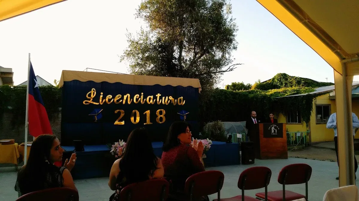 Ceremonia de licenciatura en el patio del colegio: estudiantes de IV medio recibiendo su diploma al anochecer