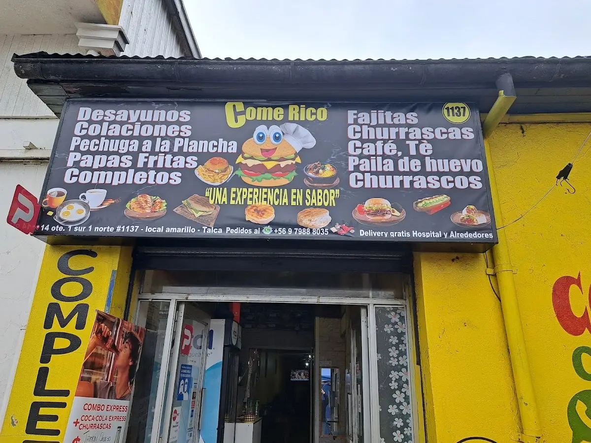 Fachada de Come Rico: local amarillo con letrero negro que lista la carta